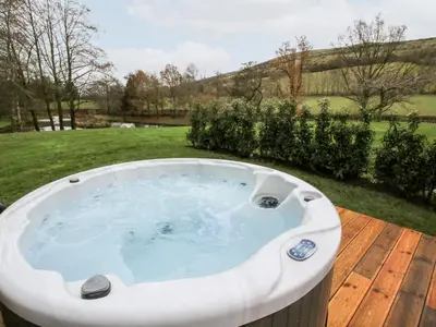 a jacuzzi tub sitting on a wooden deck at Pultheley Cottage in Montgomery