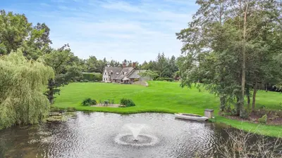 an estate with a house and a pond with a fountain at Pultheley Cottage in Montgomery