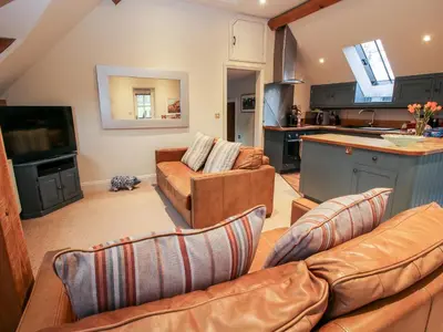 a living room with two couches and a kitchen at Pultheley Cottage in Montgomery