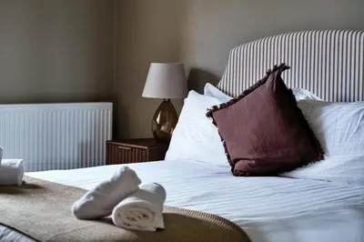 a bed with a pillow and towels on it at Finest Retreats - The Park in Onibury