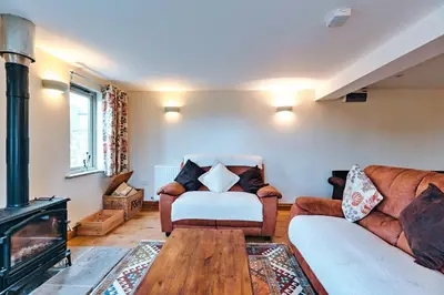a living room with a couch and a fireplace at Finest Retreats - Norton Cottage in Onibury
