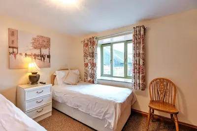 a bedroom with a bed and a window and a chair at Finest Retreats - Norton Cottage in Onibury