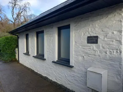 a white building with windows and a sign on it at Penglais Lodge in Aberystwyth