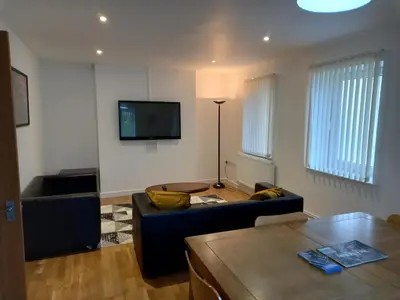 a living room with a couch and a tv at Penglais Lodge in Aberystwyth