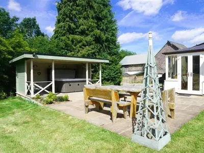 a patio with a table and a bench in a yard at 4 Bed in Brecon oc-bn151 in Devynock