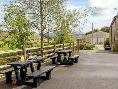 two picnic tables sitting next to a fence at 1 Bed in Brecon oc-bn034 in Cray
