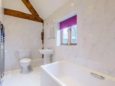 a bathroom with a tub and a toilet and a sink at 4 Bed in Newtown oc-86784 in Bettws Cedewain