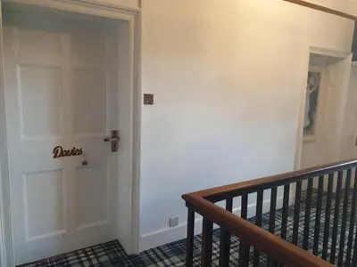 a hallway with a white door and a staircase at Penygelli Apartments in Newtown