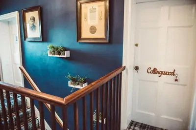 a hallway with blue walls and a staircase with potted plants at Penygelli Apartments in Newtown