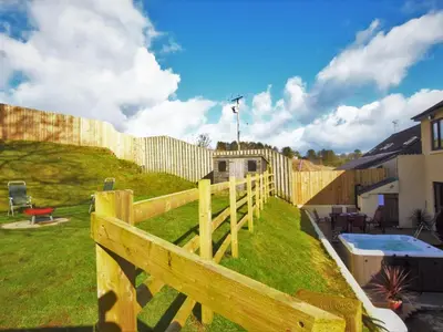 a wooden fence in a yard with a pool at 5 Bed in Llanybydder oc-75907 in Llanwenog