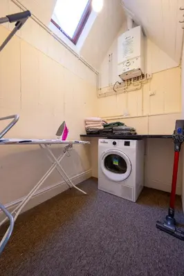 a laundry room with a washing machine and a table at Town Centre Cottage 3 Bedroom inc Parking (1 car) in Shrewsbury