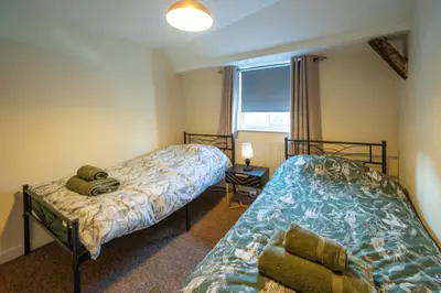 a bedroom with two beds and a window at Town Centre Cottage 3 Bedroom inc Parking (1 car) in Shrewsbury