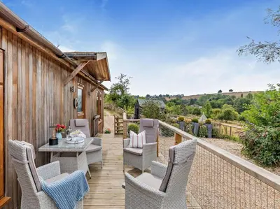 a patio with chairs and a table on a wooden deck at 2 Bed in Leominster oc-78637 in Stoke Prior