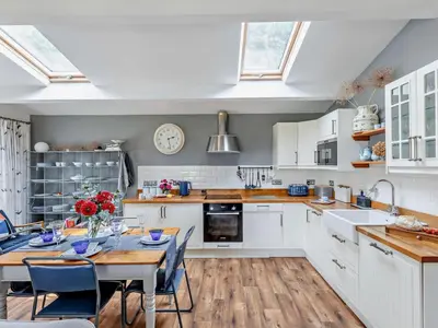 a kitchen with white cabinets and a table with chairs at 2 Bed in Leominster oc-78637 in Stoke Prior