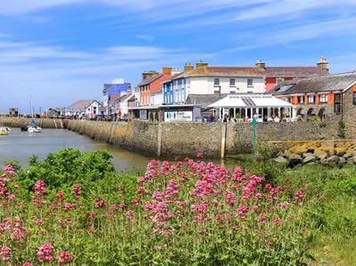 a group of pink flowers next to a river with buildings at 2 Bed in Lampeter oc-43293 in Tregaron