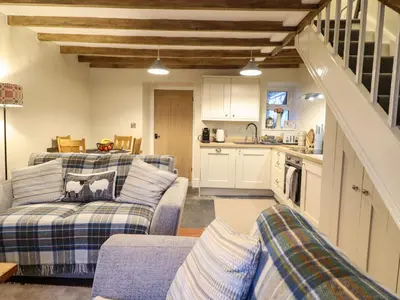 a living room with two couches and a kitchen at Bwthyn Y Bugail in Blaenau-Ffestiniog
