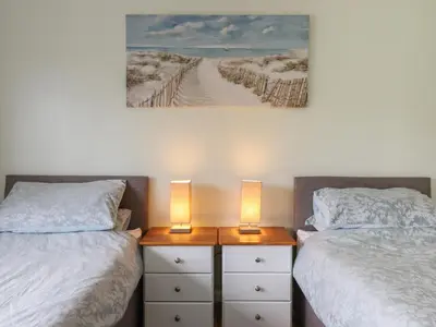 a bedroom with two beds and two lamps on dressers at Craig Yr Ronwy in Bala