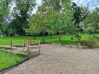 a wooden fence in a park with trees and grass at The Barn at the Mill in Selattyn