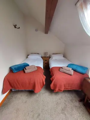 a room with two beds in a attic at The Barn at the Mill in Selattyn