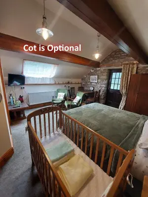 a room with a bed and a sign that says got isoptional at The Barn at the Mill in Selattyn