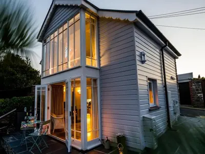 a tiny house with large windows on a patio at Y Stabl in New Quay