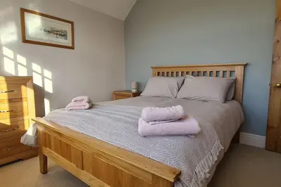 a bedroom with a bed with two towels on it at Holiday Cottage in Snowdonia (Sleeps 10) in Harlech