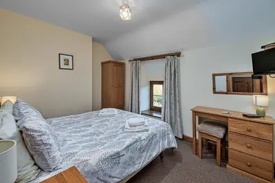 a bedroom with a bed and a desk and a television at Finest Retreats - Llechwedd Mawr in Talybont