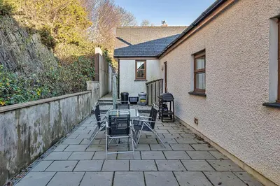 a patio with chairs and tables and a building at Finest Retreats - Eithinog in Talybont