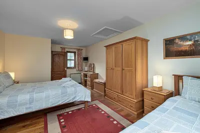 a bedroom with two beds and a wooden cabinet at Finest Retreats - Eithinog in Talybont