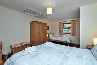 a bedroom with a large bed and a window at Finest Retreats - Eithinog in Talybont