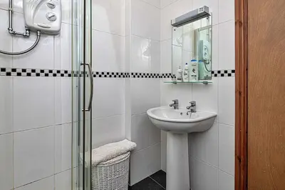 a white bathroom with a sink and a shower at Finest Retreats - Helygen in Talybont