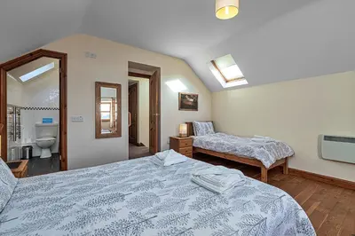 a bedroom with two beds and a bathroom at Finest Retreats - Helygen in Talybont
