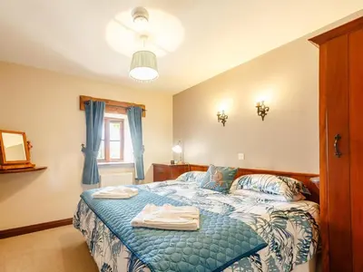 a bedroom with a blue bed with towels on it at 2 Bed in Dyffryn Ardudwy oc-89394 in Dyffryn