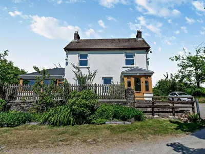 a large white house with a wooden fence at 3 Bed in Carmarthen oc-92116 in Rhyd-cymmerau