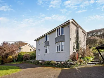 a white house with windows and a driveway at 4 Bed in Friog 42772 in Fairbourne