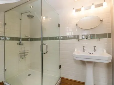 a bathroom with a glass shower and a sink at The Old Bakehouse in Leominster
