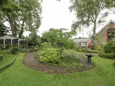a garden with a bird bath in the grass at The Old Bakehouse in Leominster