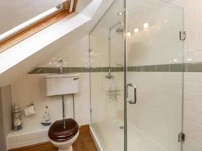 a bathroom with a toilet and a glass shower at The Old Bakehouse in Leominster