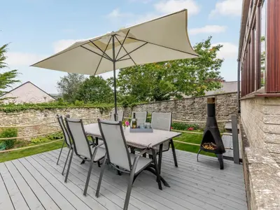 a table and chairs with an umbrella on a deck at 3 Bed in Hay-on-Wye 83593 in Hay-on-Wye