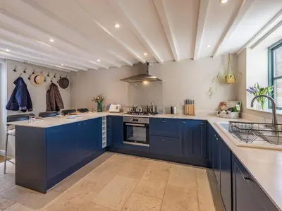 a large kitchen with blue cabinets and a stove at 3 Bed in Hay-on-Wye 83593 in Hay-on-Wye