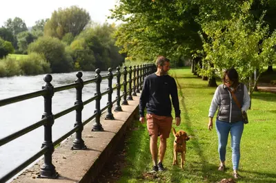 a man and a woman walking a dog on a sidewalk at 3 Bed in Aberaeron oc-b27954 in Aberaeron