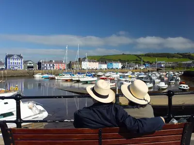 two people sitting on a bench looking at a marina at 3 Bed in Aberaeron oc-b27954 in Aberaeron