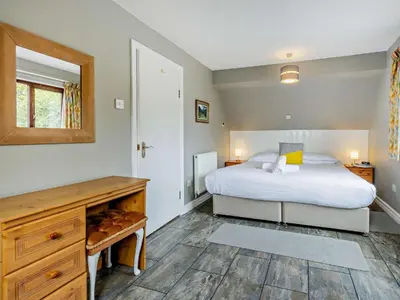 a bedroom with a bed and a desk and a mirror at 3 Bed in Aberdovey DY032 in Aberdyfi