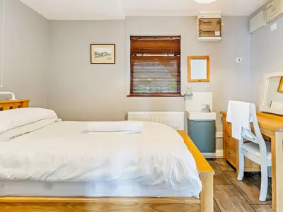 a bedroom with a bed and a desk and a sink at 3 Bed in Aberdovey DY032 in Aberdyfi