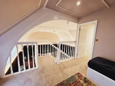 a living room with a staircase with a stair case at Unique town centre apartment with vaulted ceiling - Pass the Keys in Shrewsbury