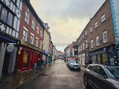 a city street with buildings and cars on a rainy day at Unique town centre apartment with vaulted ceiling - Pass the Keys in Shrewsbury
