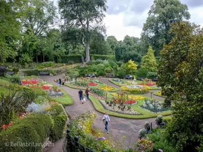 people walking around a garden with flowers and trees at Unique town centre apartment with vaulted ceiling - Pass the Keys in Shrewsbury