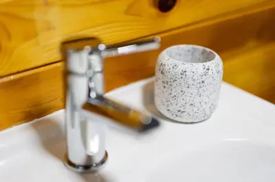 a cup sitting on a sink next to a faucet at Rural Log Cabin in Snowdonia near Coed y Brenin by Seren Short Stays in Ffestiniog