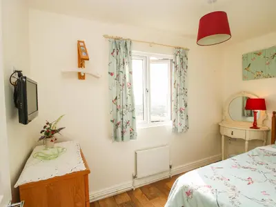 a bedroom with a bed and a window at Dragonfly Lodge in Shrewsbury