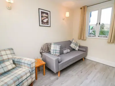 a living room with a couch and a chair at Railway Station Cottage in Llandrindod Wells